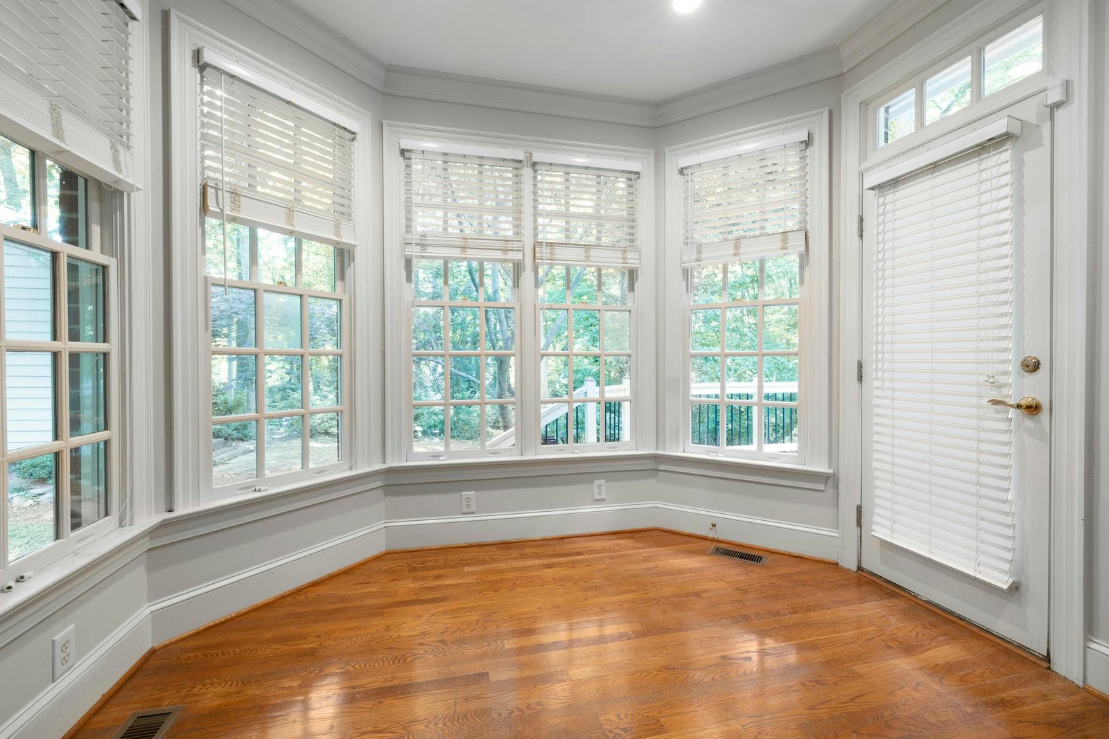 Bright interior space with large windows and wooden floors, perfect for home decor or real estate.